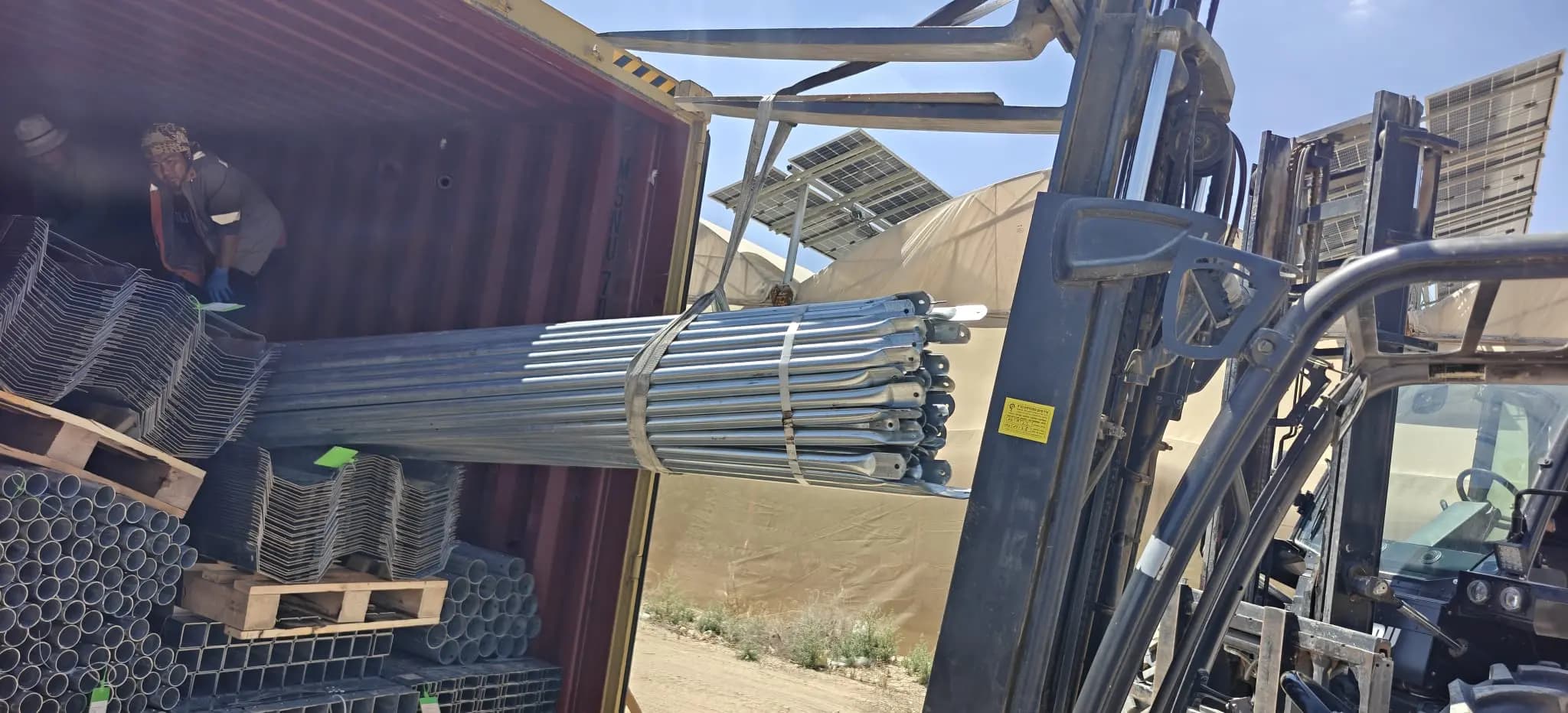 Bundles of greenhouse steel tubing in a shipping container